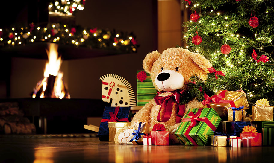 Un ours en peluche devant un sapin de Noël