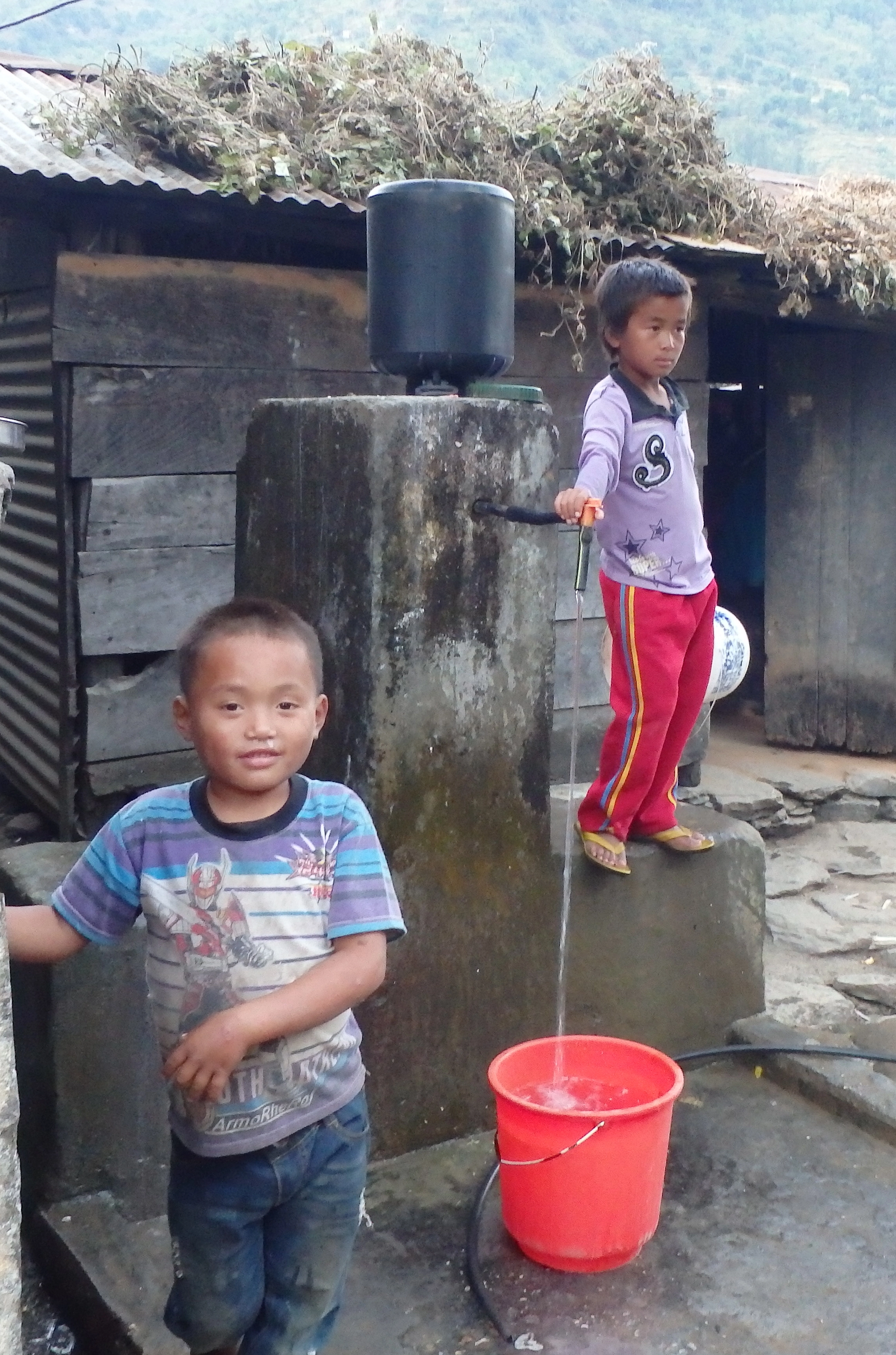 image d'enfants devant une fontaine dans un village au Népal 