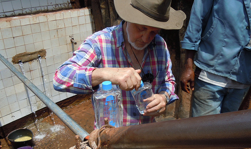 homme en train de remplir des gourdes d'eau potable