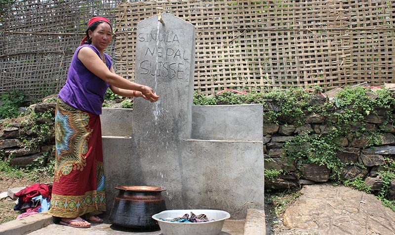 femme devant une fontaine d'eau potable au Népal