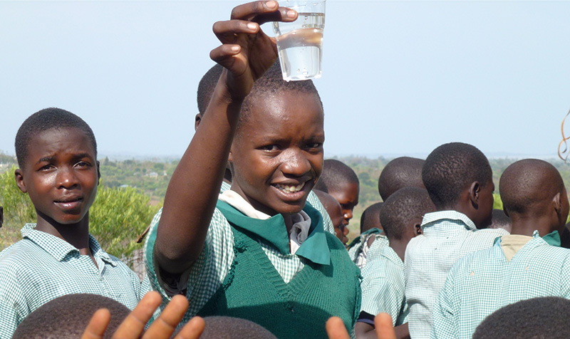 Fille levant son verre d'eau