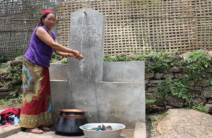 femme devant une fontaine d'eau potable au Népal 