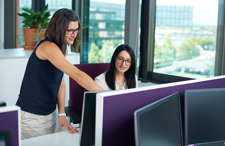 femmes échangeant devant un écran d'ordinateur