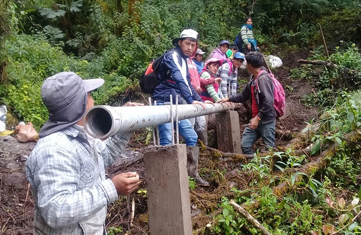 Groupe de personnes en train d'installer des canalisations en Andes équatoriennes 